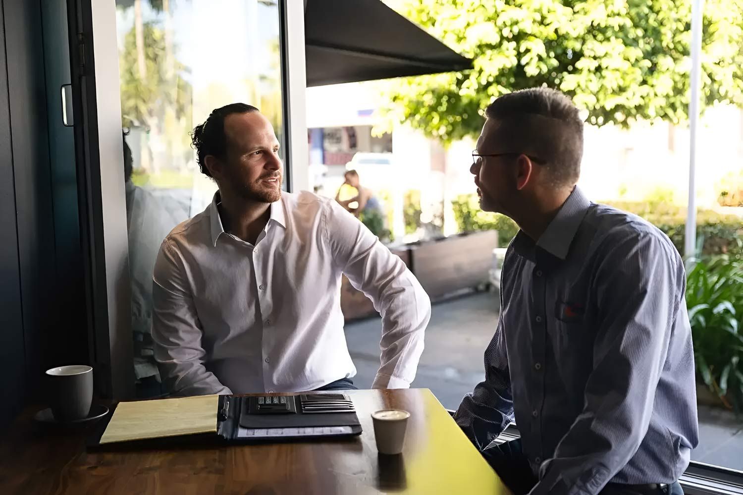 Two Men Are Seated At A Table, Engaged In Conversation — Whitson Dawson Accountants in Mackay, QLD