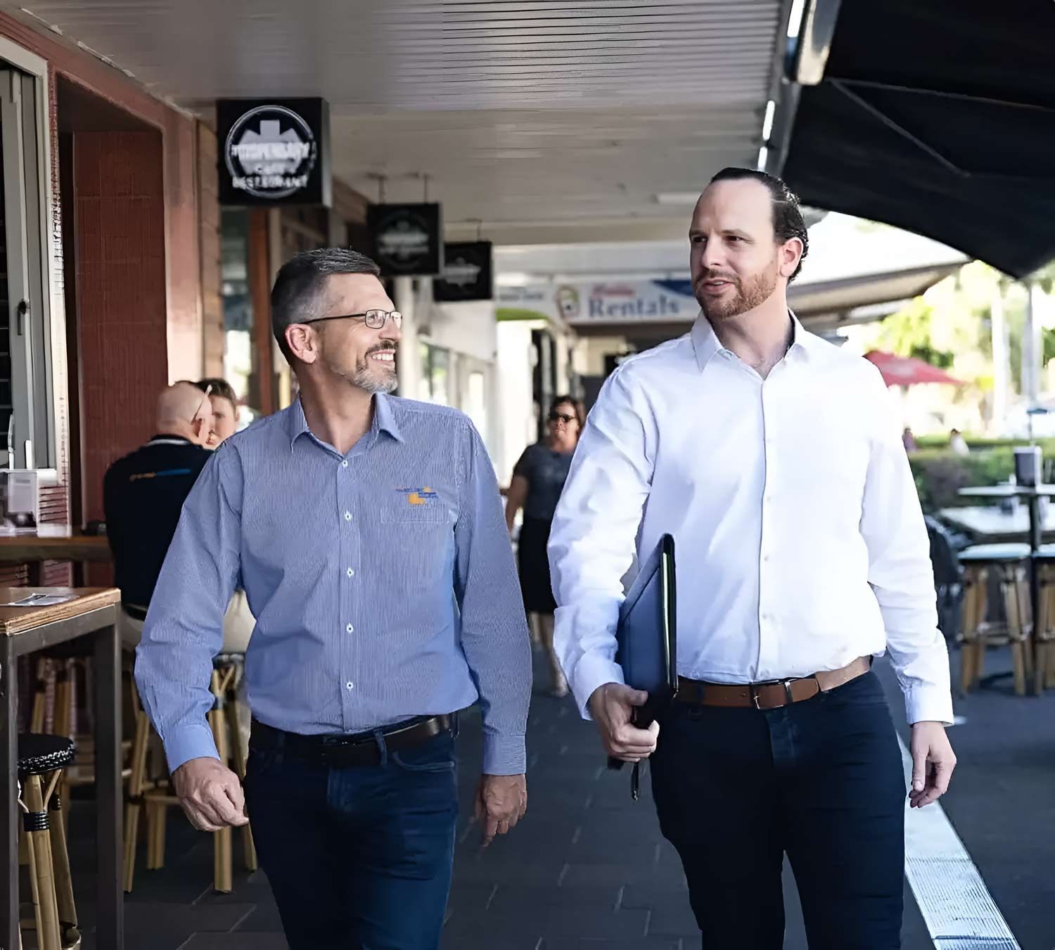 Two Accountant Men Are Walking Down A Sidewalk — Whitson Dawson Accountants in North Whitsundays, Queensland