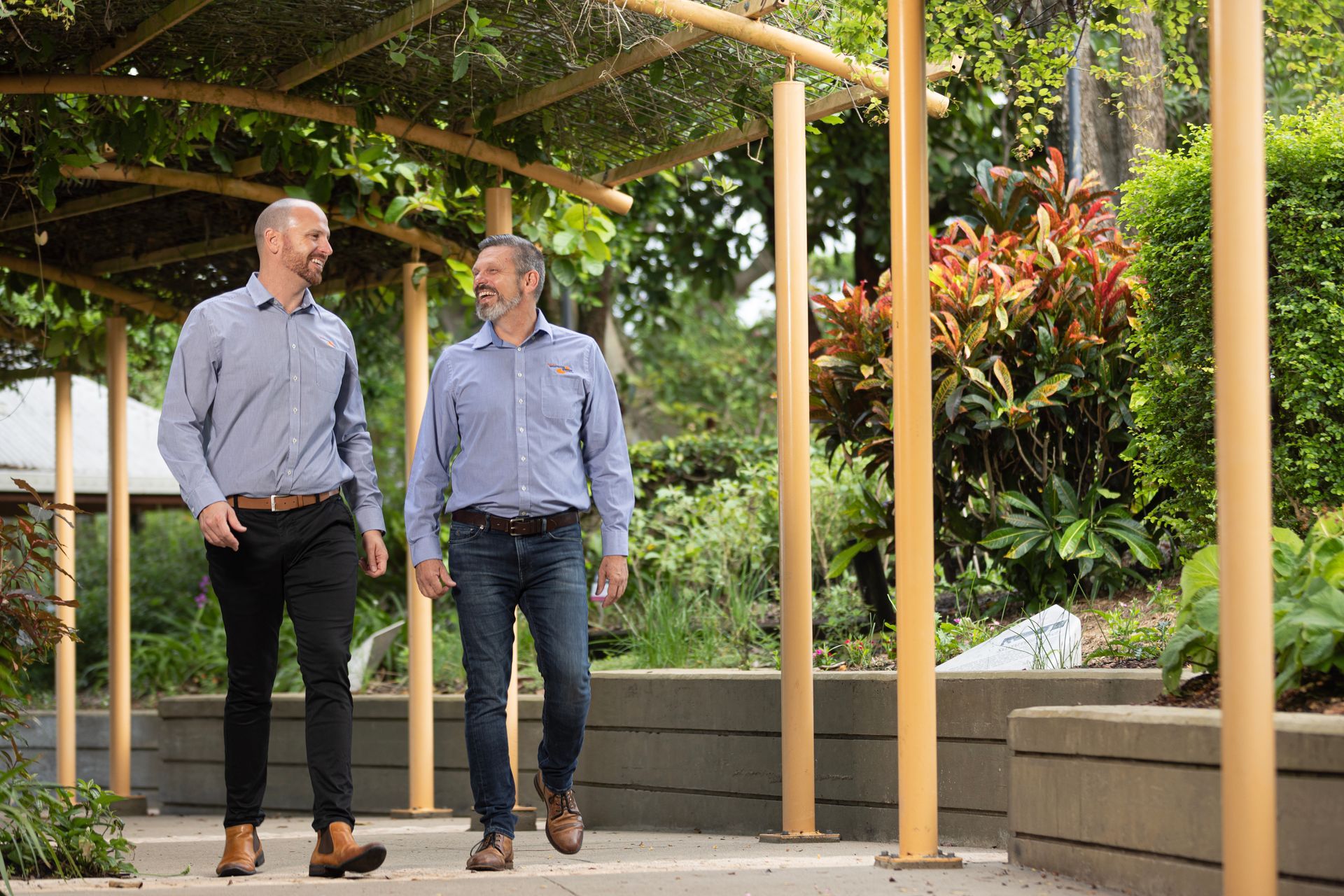 Two Men Are Sitting At A Table Talking To Each Other Outside The Restaurant — Whitson Dawson Accountants in Mackay, QLD