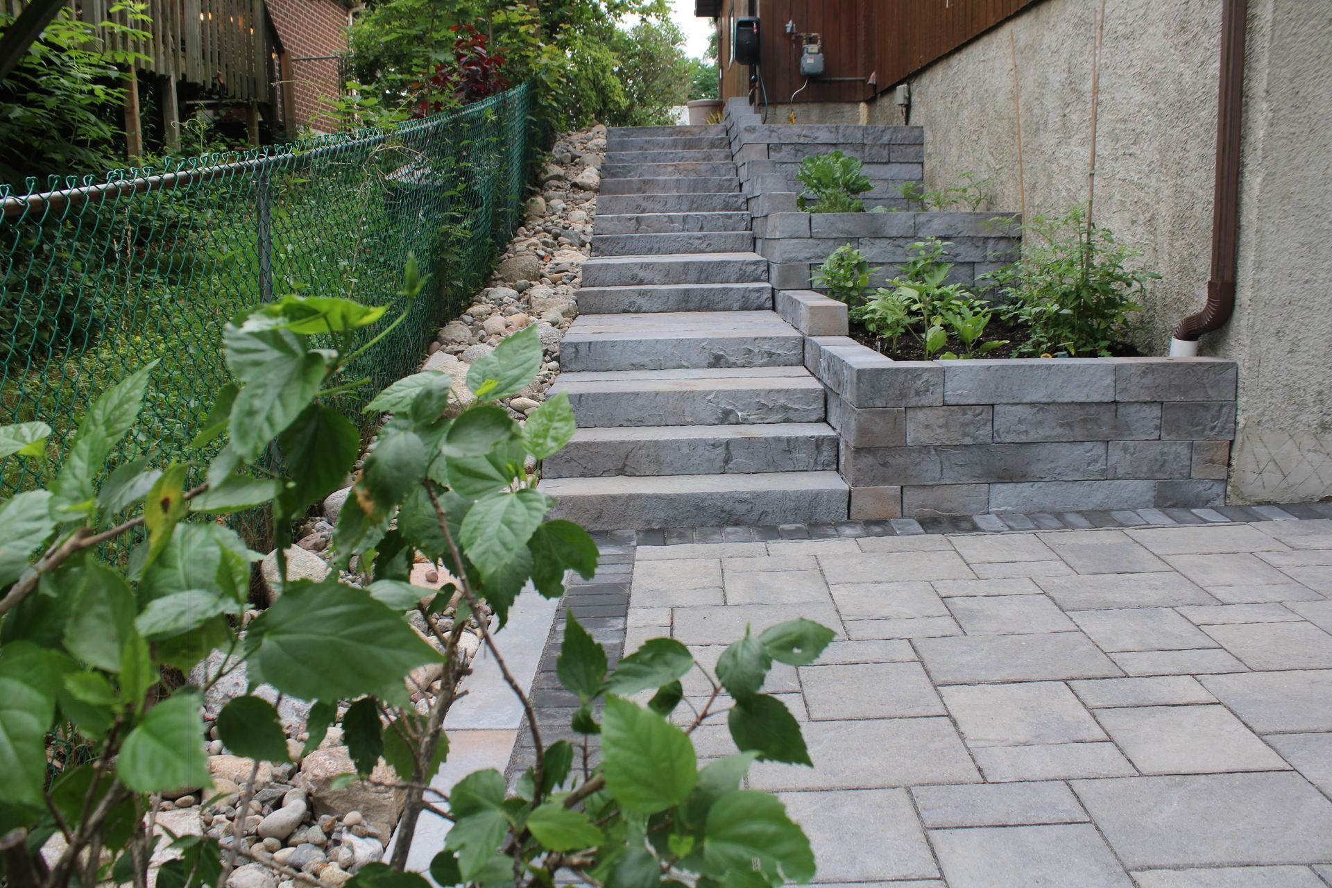 A house with a stone wall in front of it