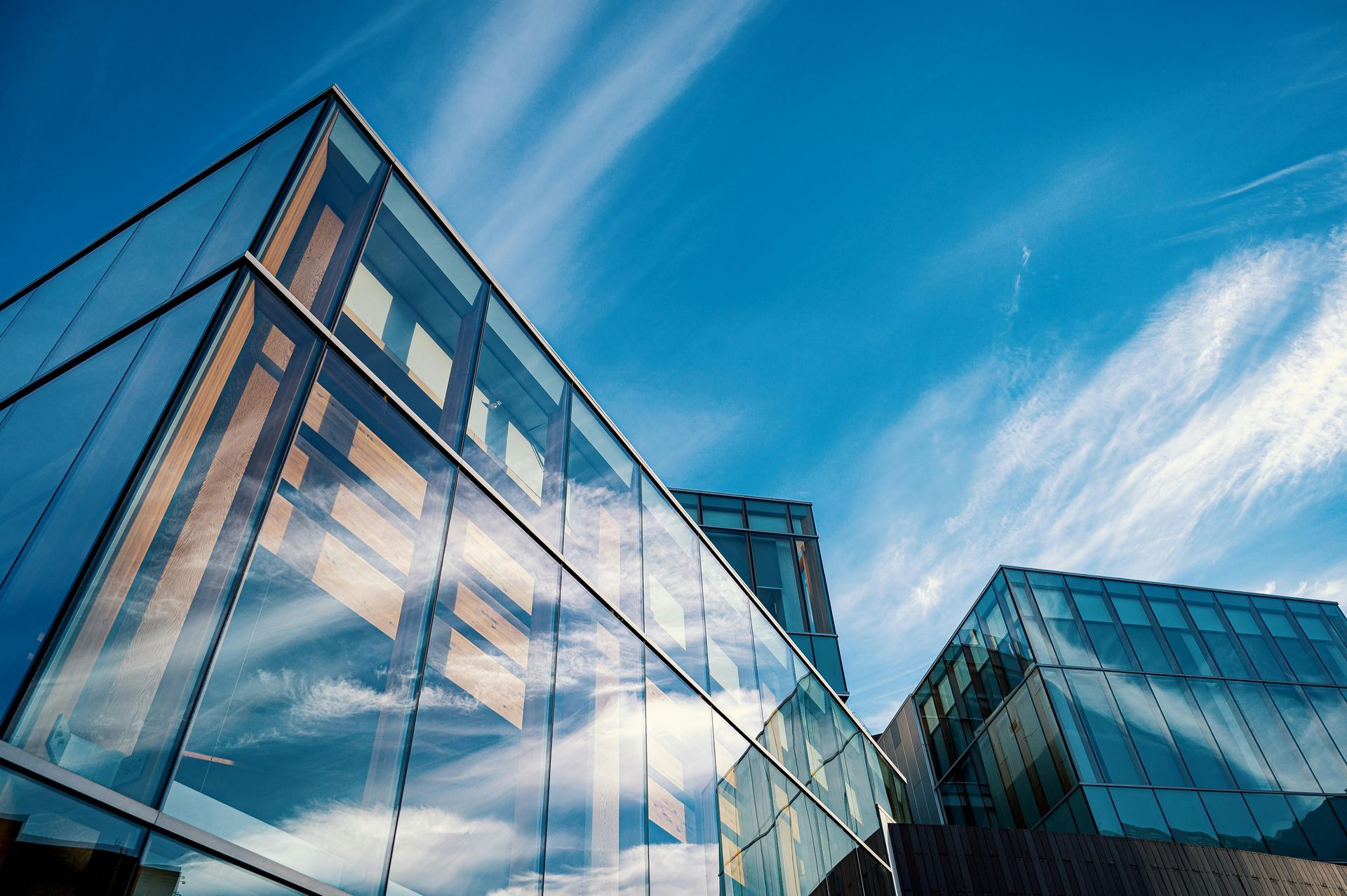 A large glass building with a blue sky in the background.
