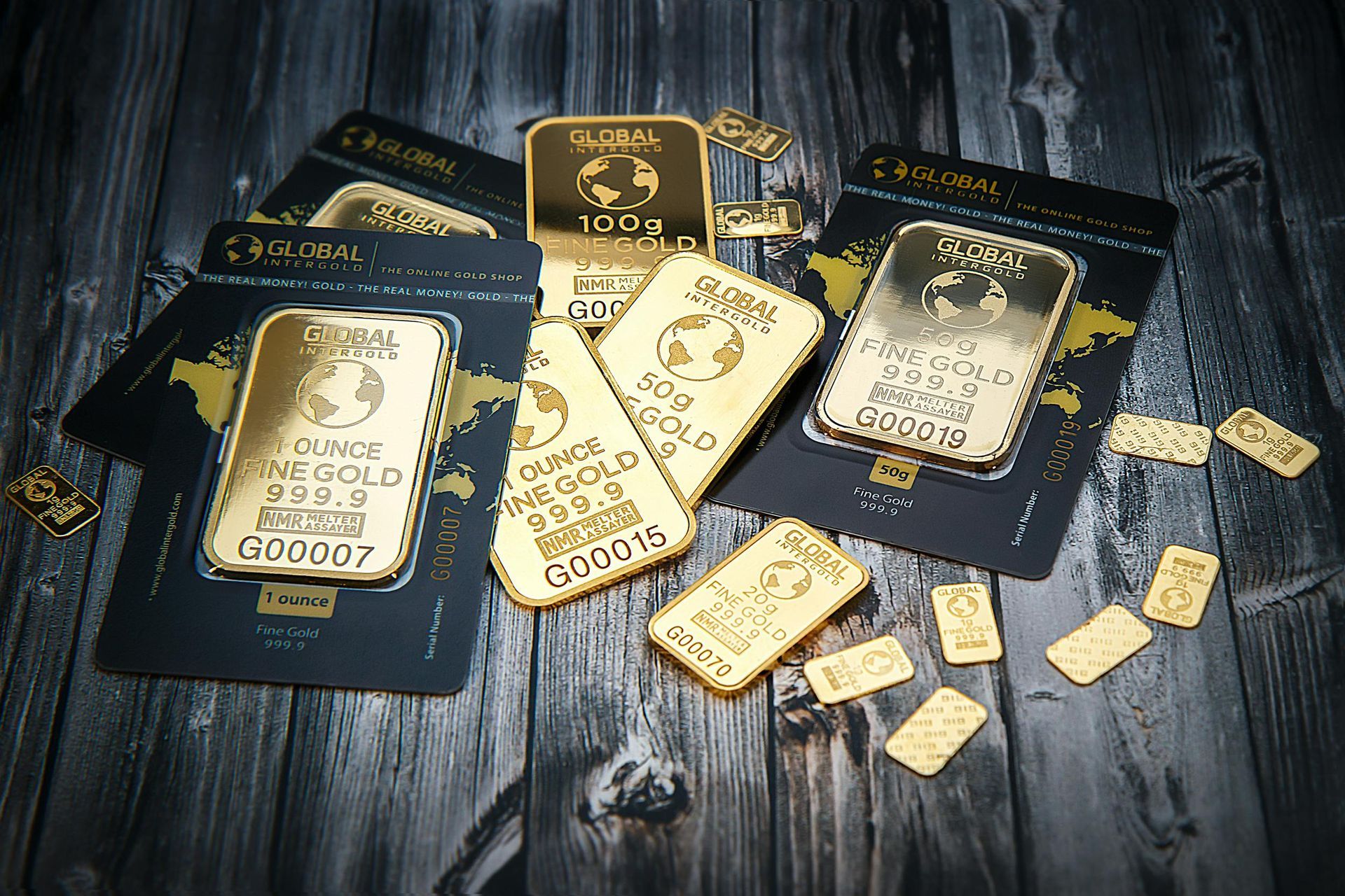 A bunch of gold bars are sitting on a wooden table.