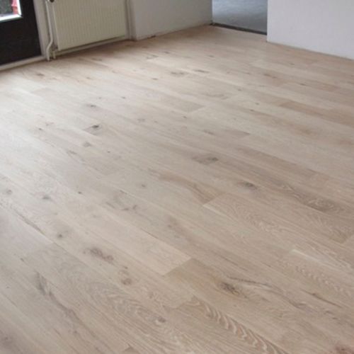 Een kamer met een houten vloer en een deur.