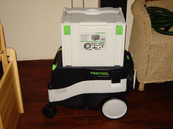 Een festool stofzuiger staat op een houten vloer