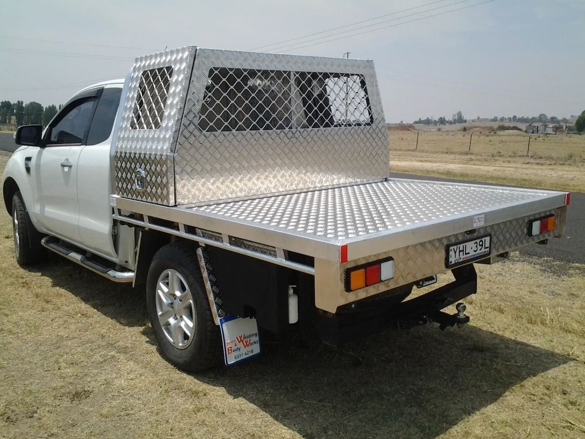 A White Truck With A Stainless Steel Bed Is Parked On The Side Of The Road — Bathurst Welding & Body Works In Bathurst, NSW