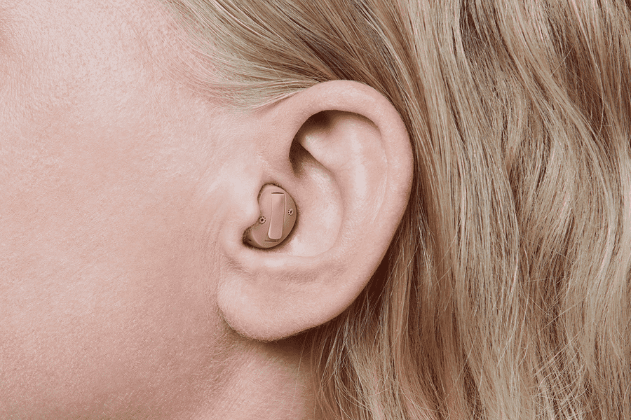 A close up of a woman 's ear with a hearing aid in it.