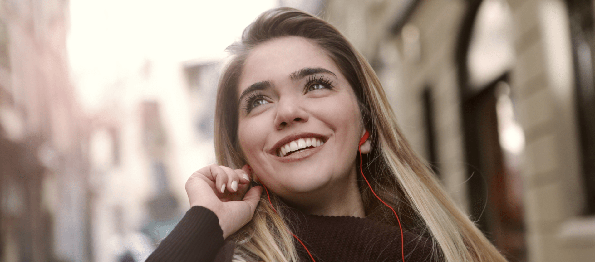 Femme heureuse qui écoute de la musique avec des écouteurs et des adapteurs personnalisés pour écouteurs.