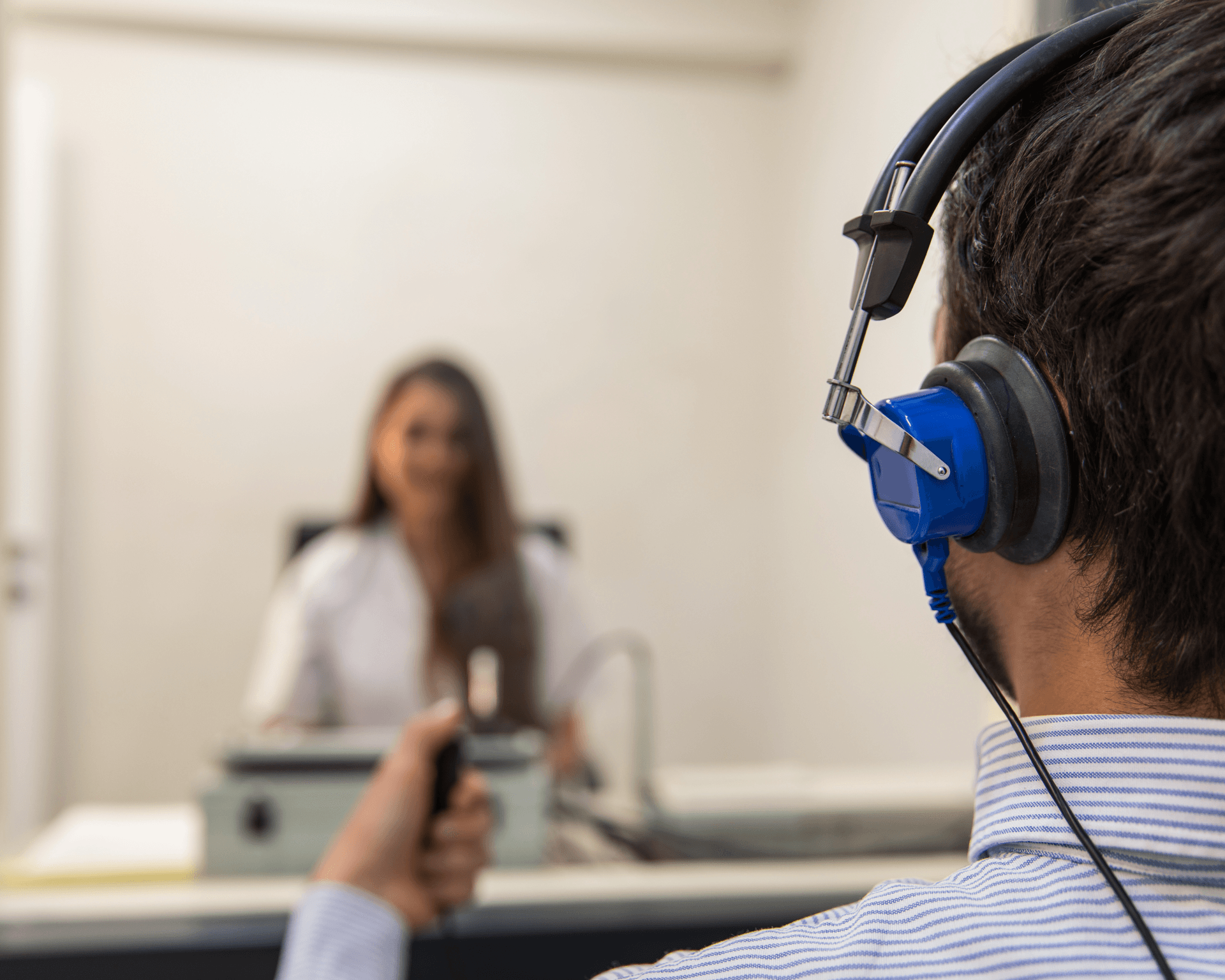 A man wearing headphones is talking to a woman.