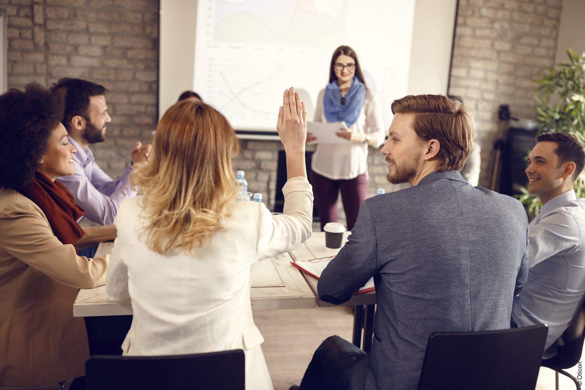 A group of people are sitting around a table giving each other a high five.