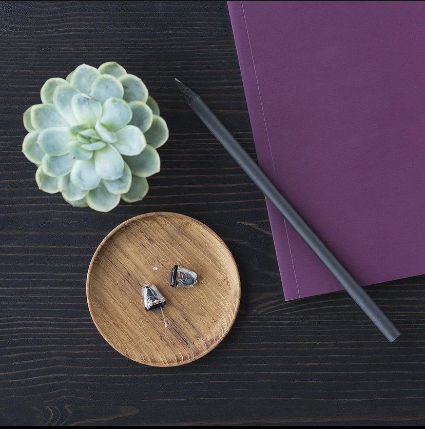 Une plaque en bois avec un crayon et une fleur dessus