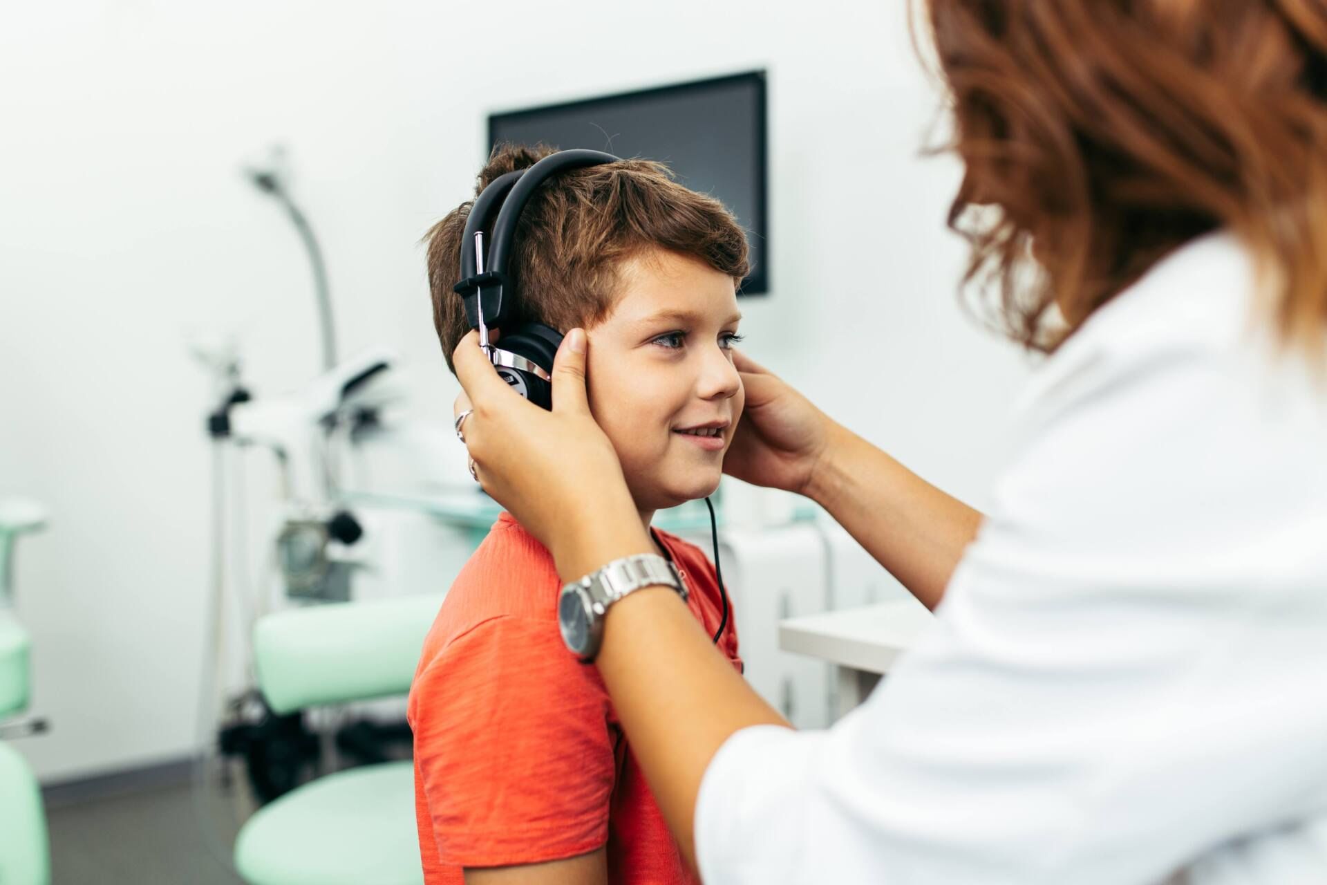 Audiologiste qui effectue un test auditif Lorraine à un garçon