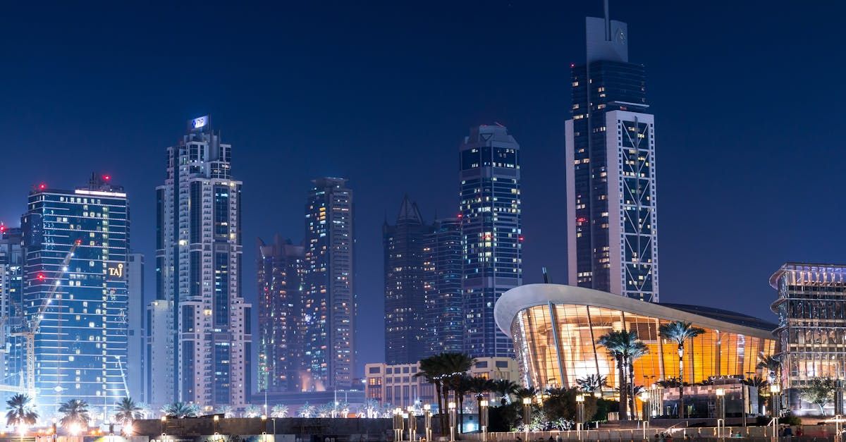 A city skyline at night with a large building in the foreground.