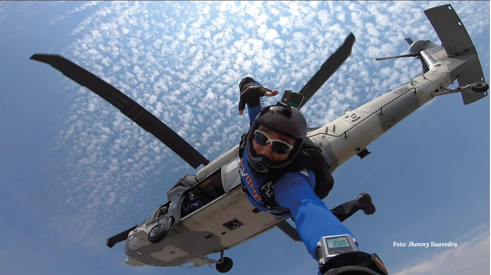 A person is jumping out of a helicopter with a watch on their wrist