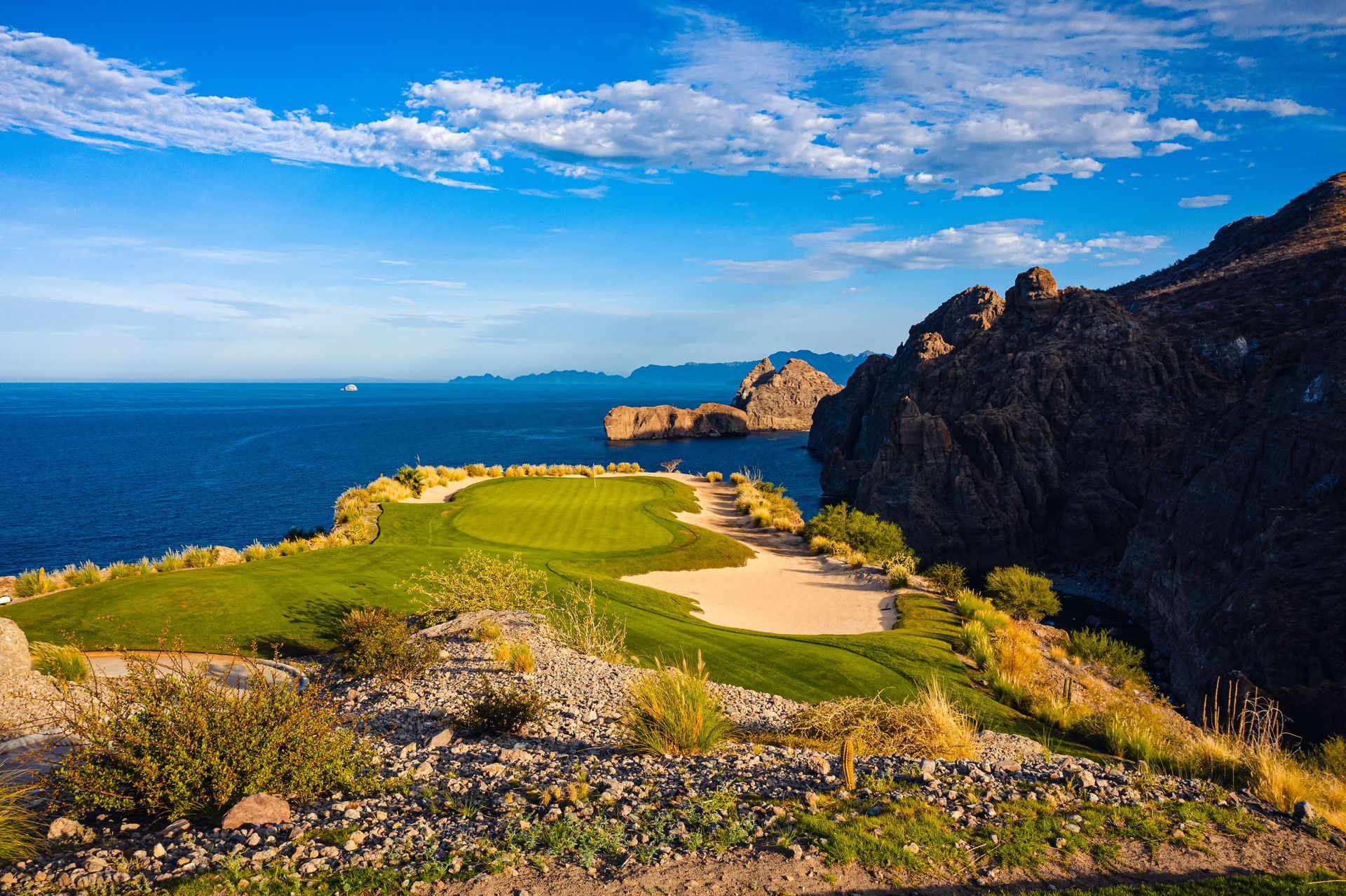 A golf course on a cliff overlooking the ocean.