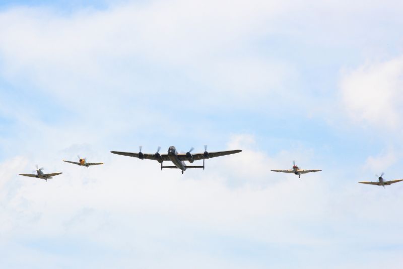 A group of planes are flying in formation in the sky.