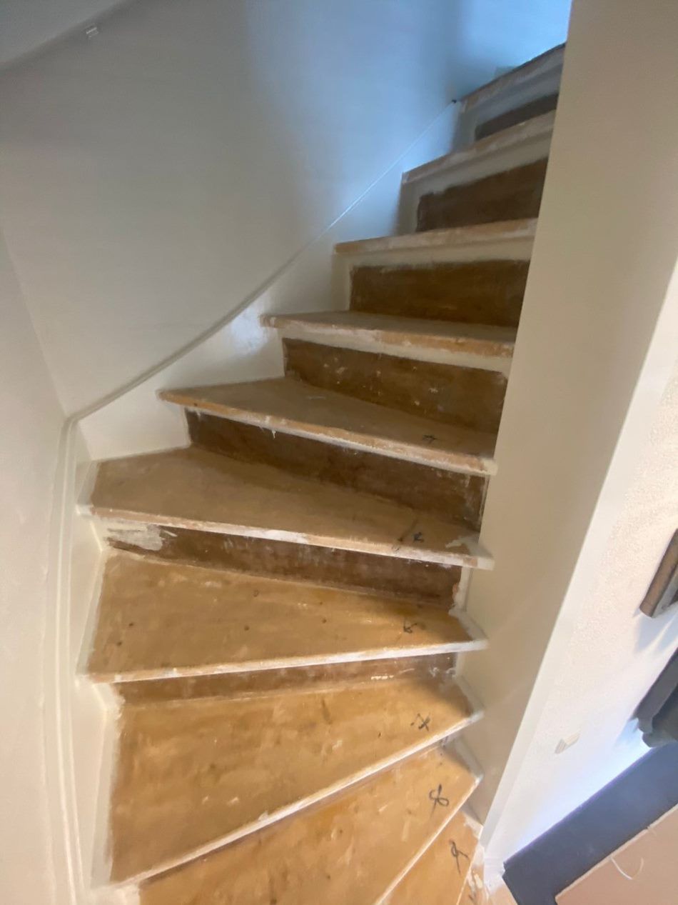 Een trap met houten treden en een witte leuning in een kamer.