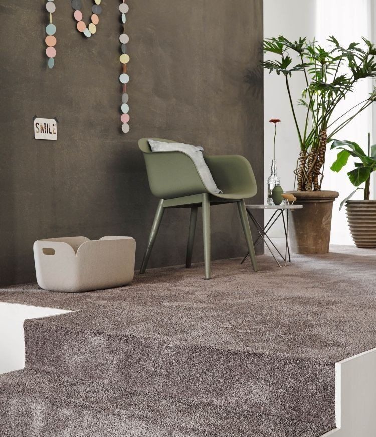 Een woonkamer met een groene stoel en een witte mand