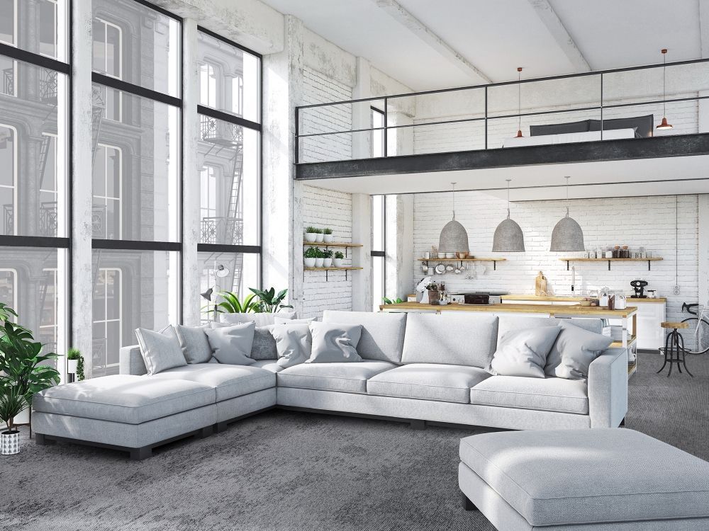 Een woonkamer met een grote witte hoekbank en een balkon.