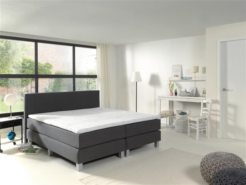 Een slaapkamer met een bed en een bureau erin