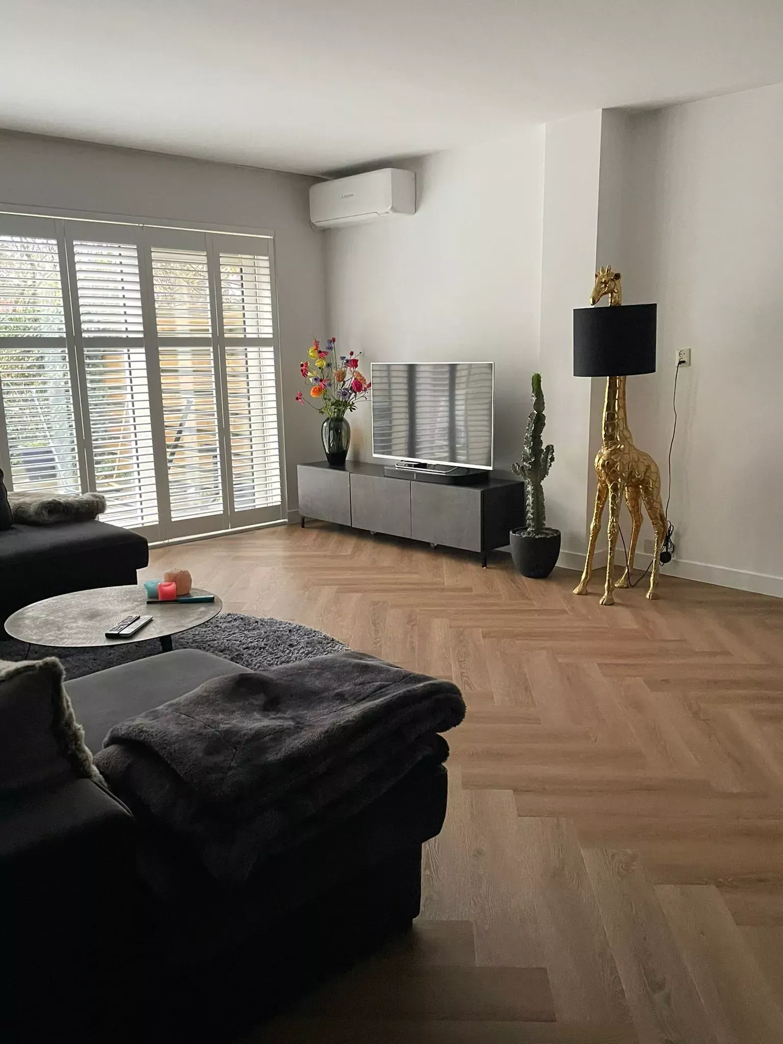 Een woonkamer met een bank, stoel, tafel en een lamp.