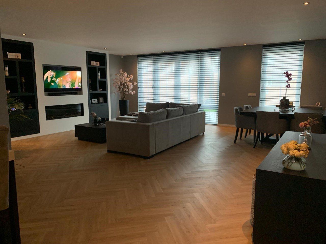 Een woonkamer met een bank en een televisie aan de muur.