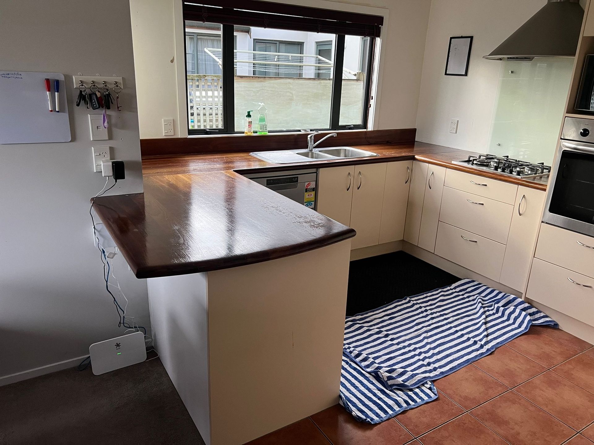 A kitchen with a striped towel on the floor