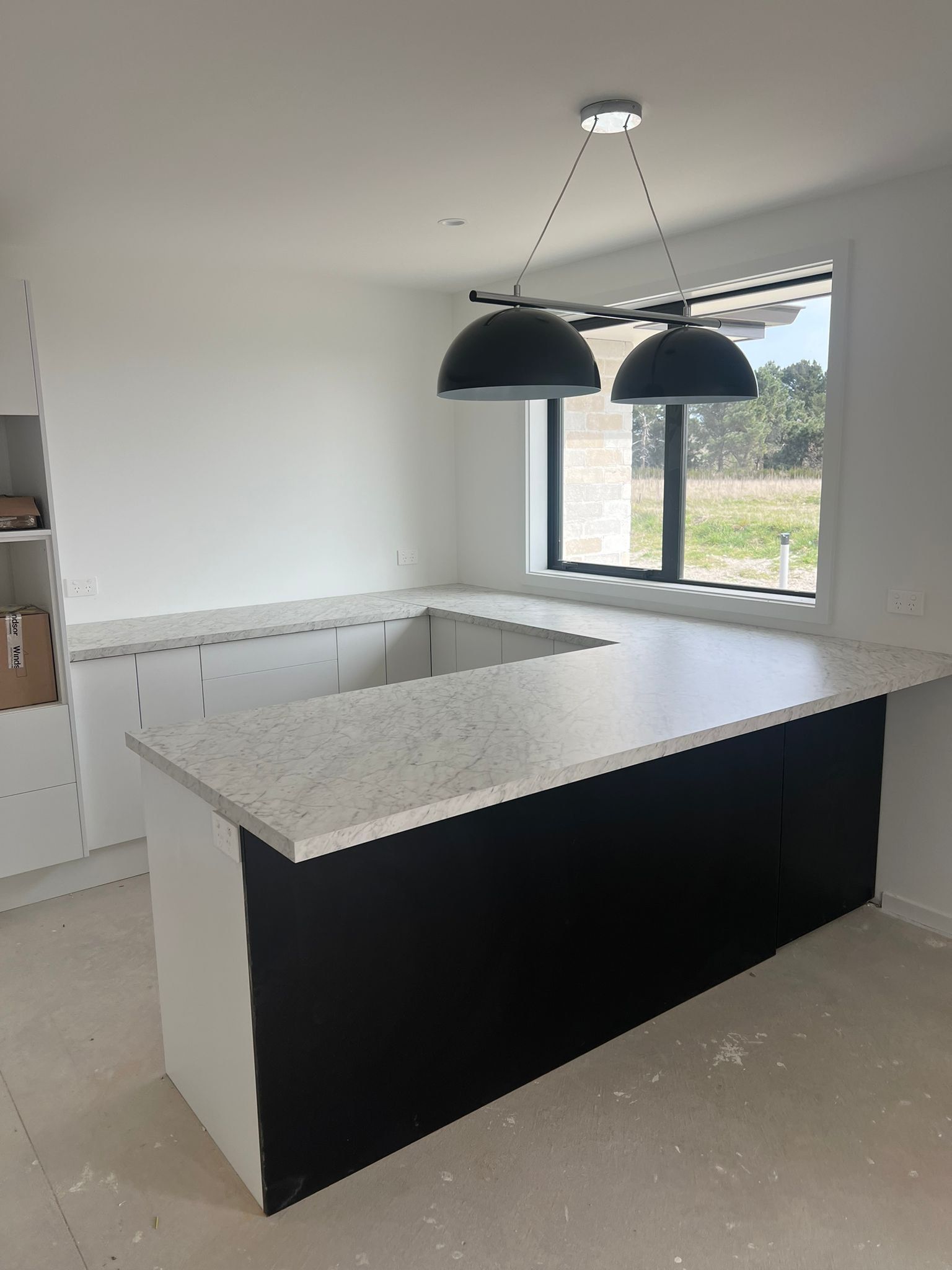 A kitchen with a large island and a window.