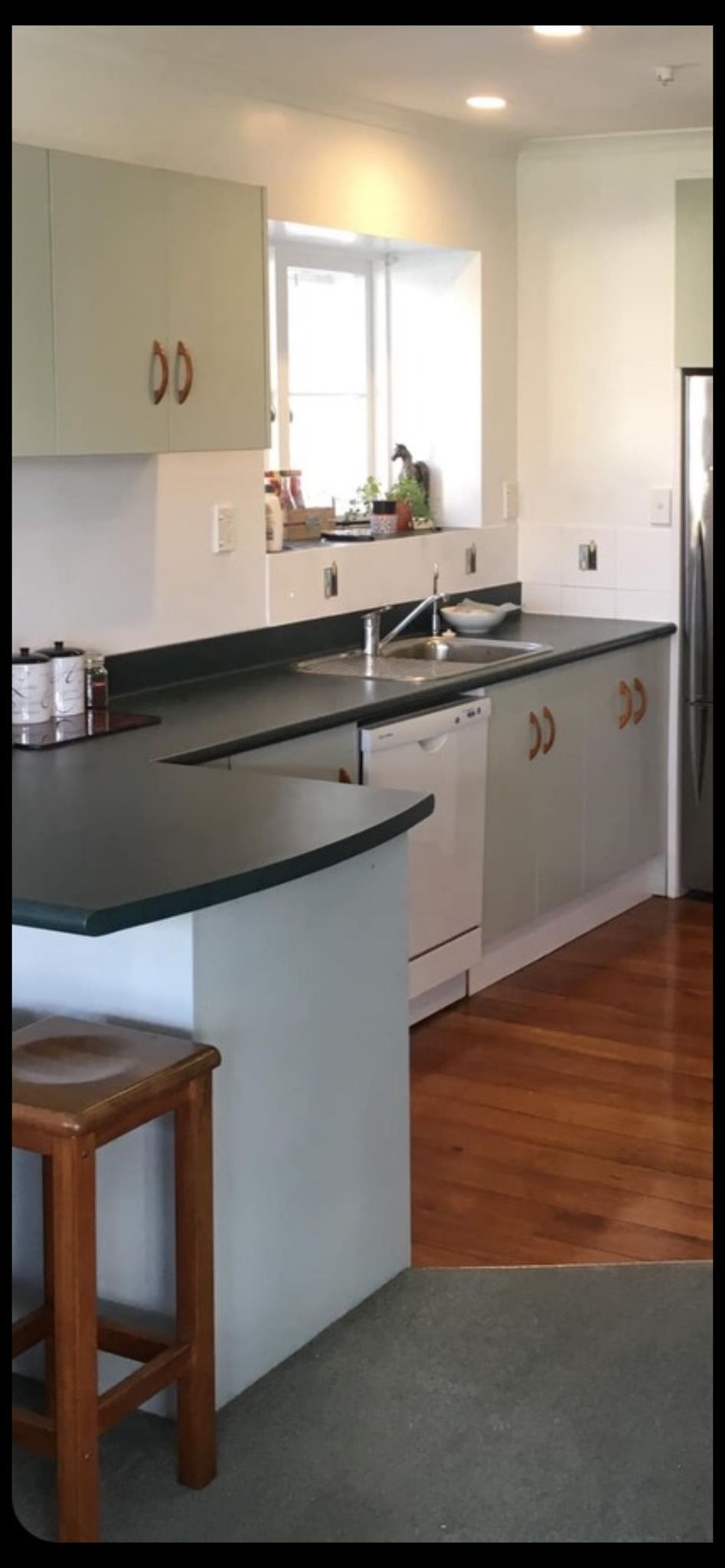 A kitchen with white cabinets and black counter tops