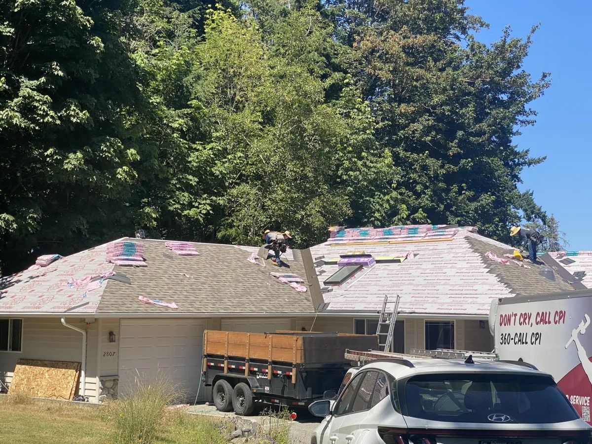 A car is parked in front of a house that is being remodeled.