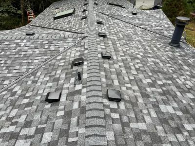A close up of a roof with a ladder in the background.