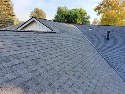 The roof of a house with a gray shingle roof.