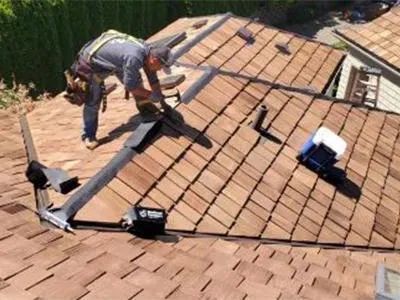 A man is working on the roof of a house.