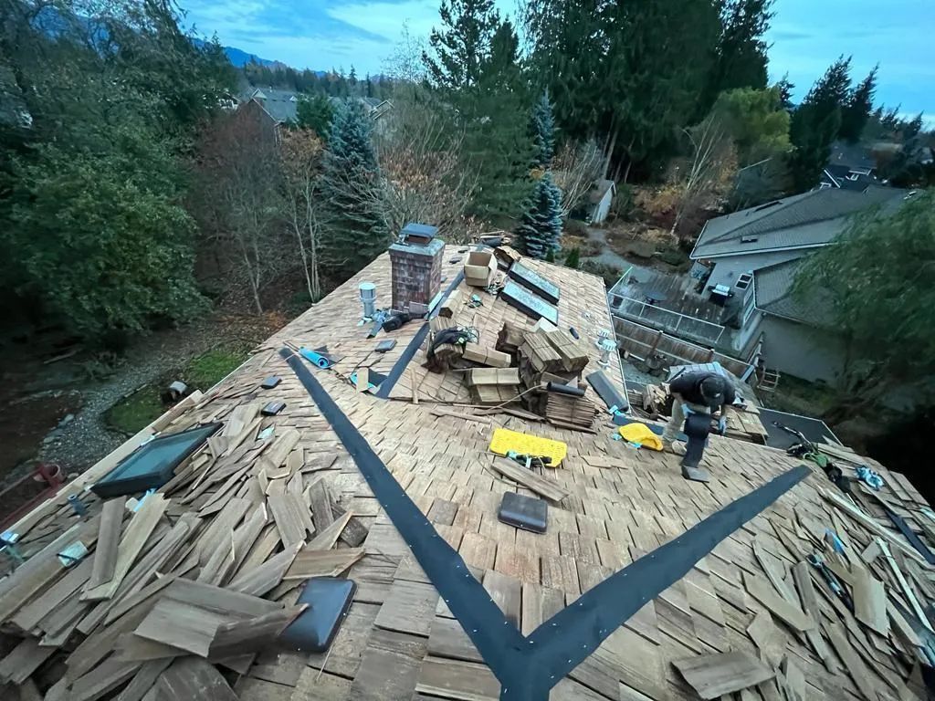 A man is working on the roof of a house.