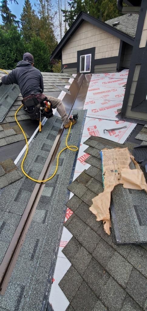 A man is working on the roof of a house.