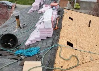 A roof is being repaired with a hose and a fan.
