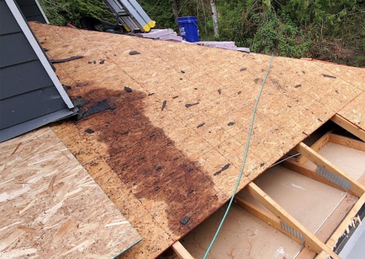 The roof of a house is being built and the roof is covered in plywood.