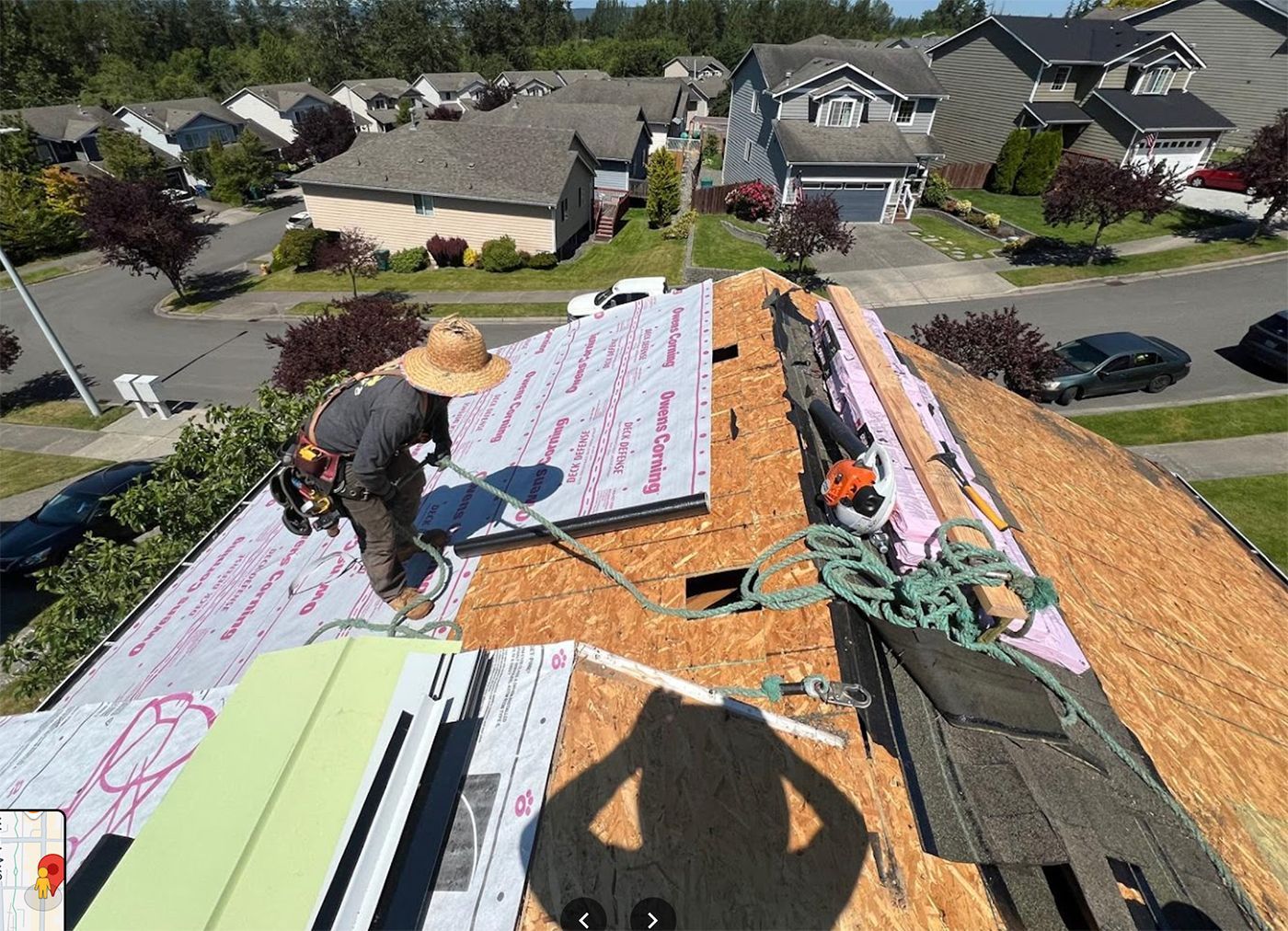 Two men are working on the roof of a house.