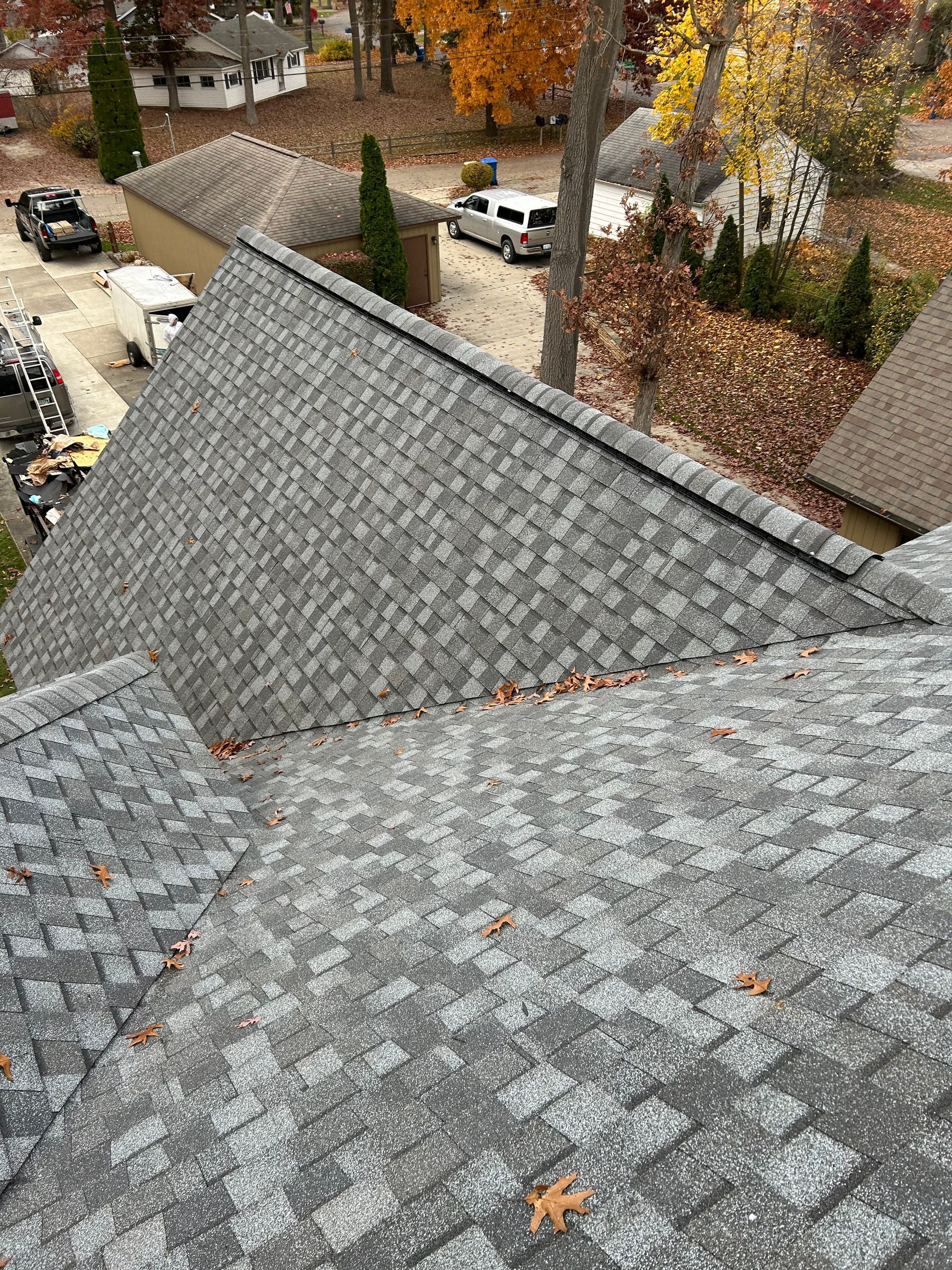 A vertical, windowless opening in a white wall reveals an interior staircase. The roof above has missing shingles.
