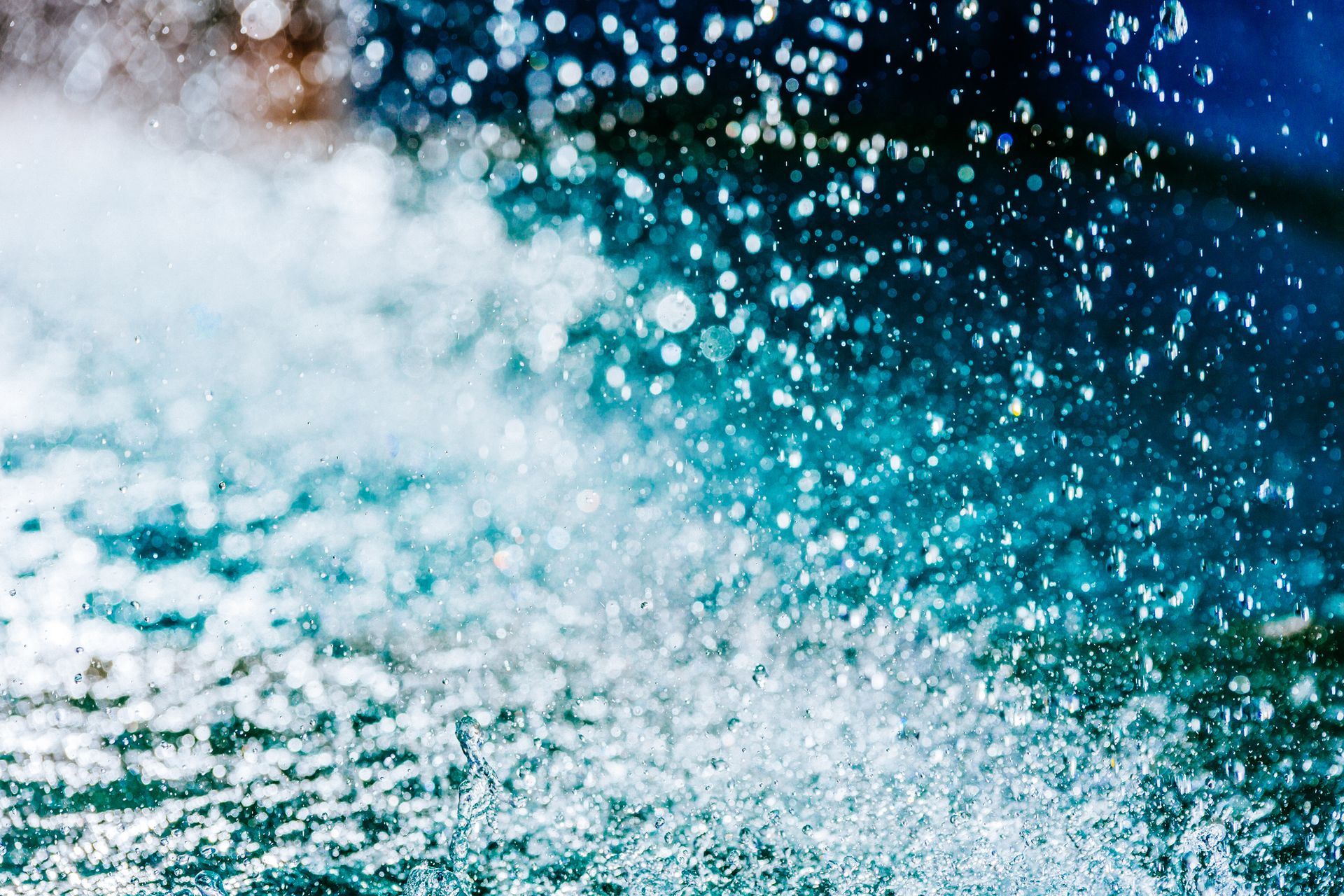 Vibrant blue water splash background illustrating professional drain cleaning with hydro jetting.