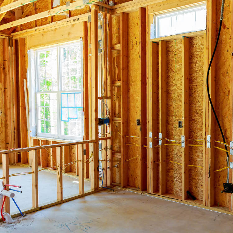 A room in a house under construction with wooden walls and a window.