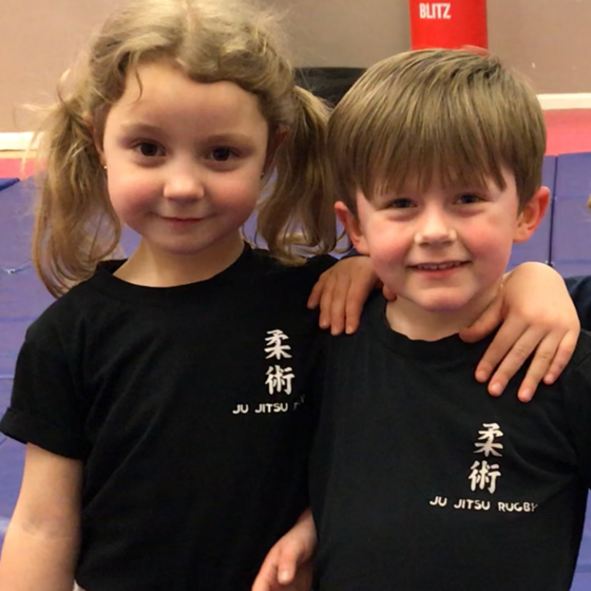 A boy and a girl are posing for a picture in front of a blitz sign