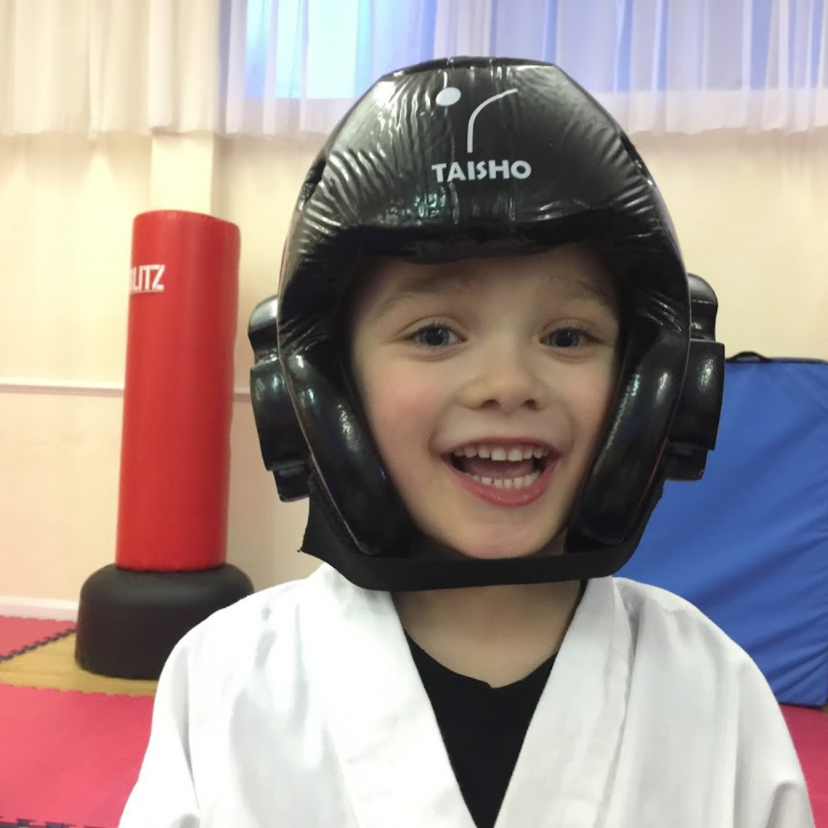 A young boy wearing a helmet that says taisho on it