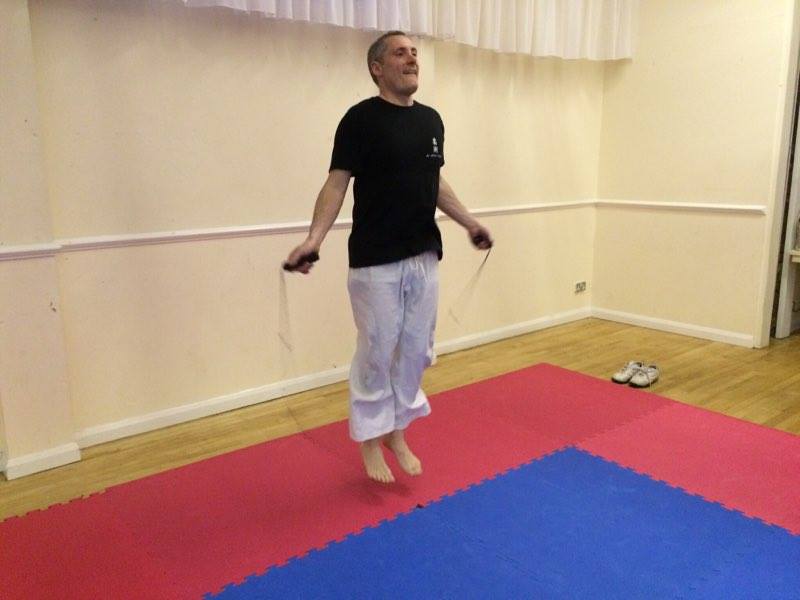 A man is jumping a jump rope in a gym