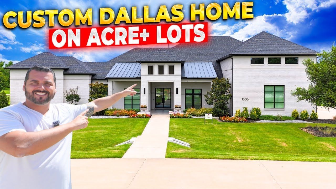 Man points at a modern white house with black trim and a green lawn in Dallas.