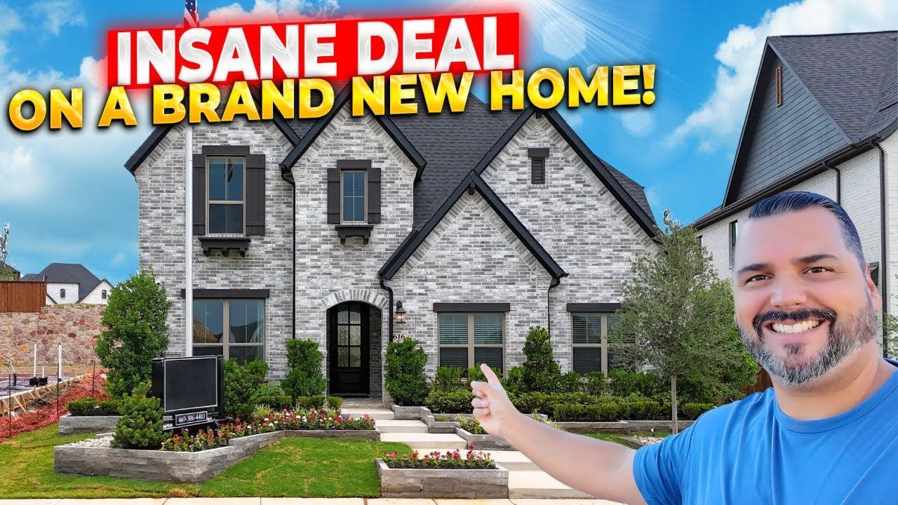 A man is giving a thumbs up in front of a brick house.
