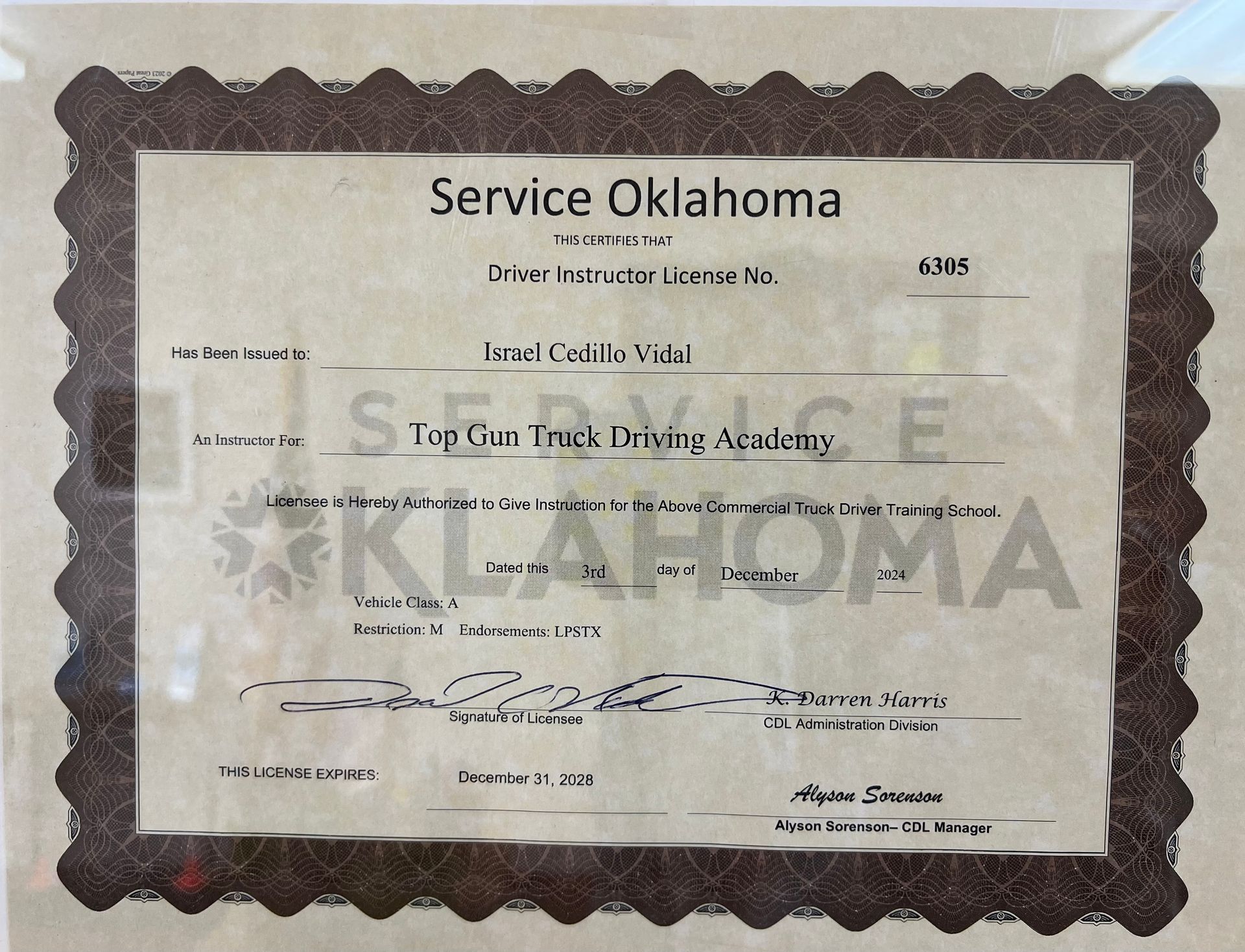 Man in plaid shirt and vest smiles in front of a white semi-truck, holding a tablet. Man in plaid shirt and vest smiles in front of a white semi-truck, holding a tablet.