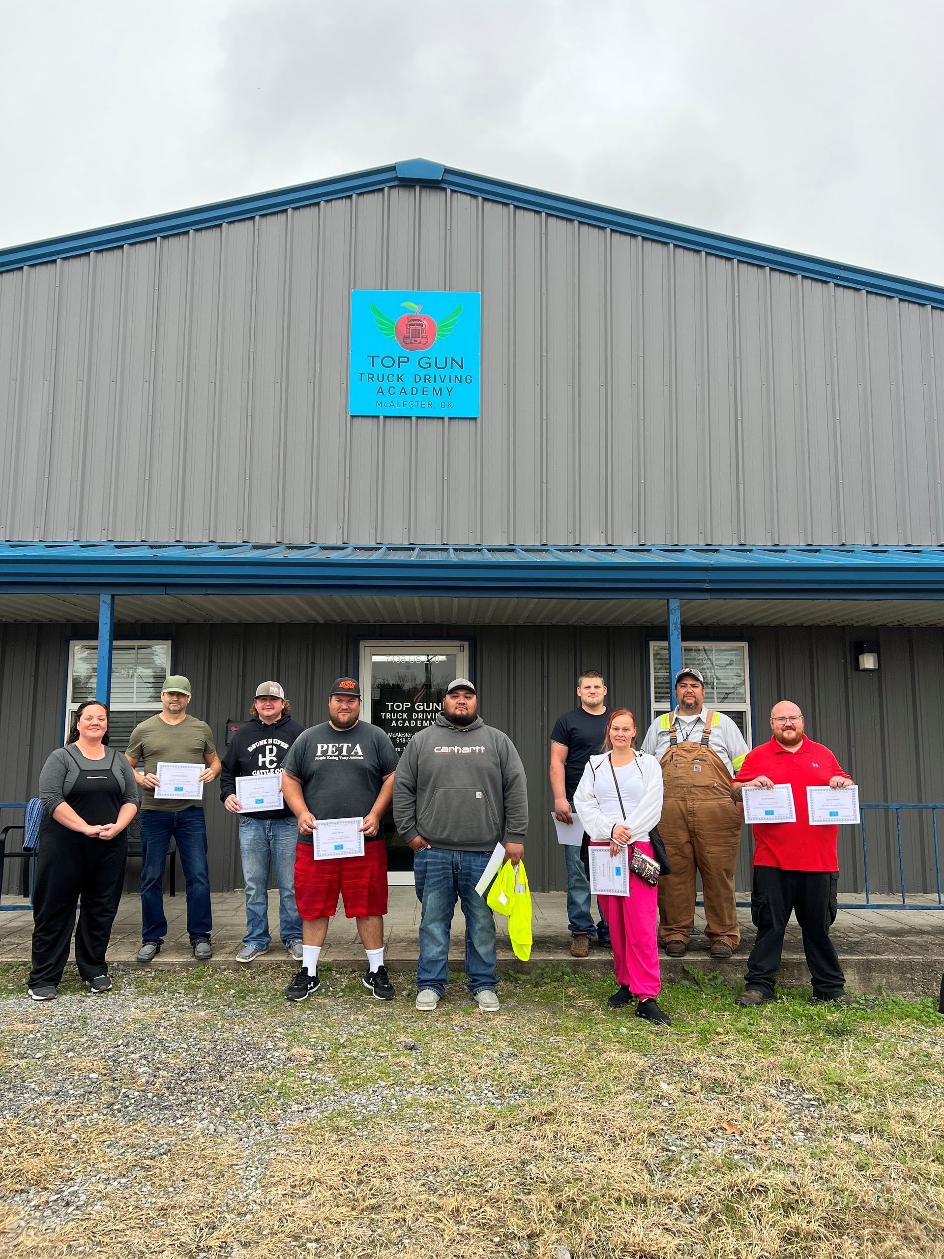 Person driving a truck, wearing an orange safety vest, looking focused.
