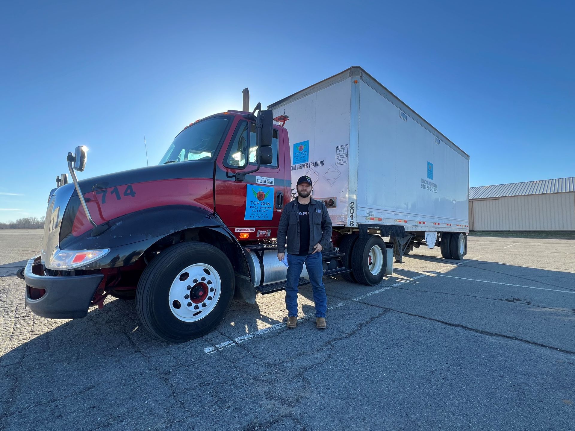 Man driving a truck, hands on steering wheel and gear shift; interior shot.