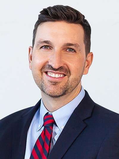 A man in a suit and tie is smiling for the camera.