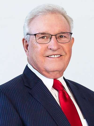 A man in a suit and tie is smiling for the camera.